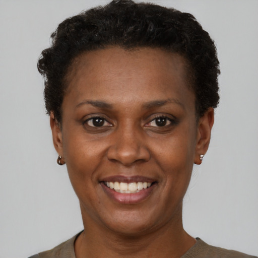 Joyful black young-adult female with short  black hair and brown eyes