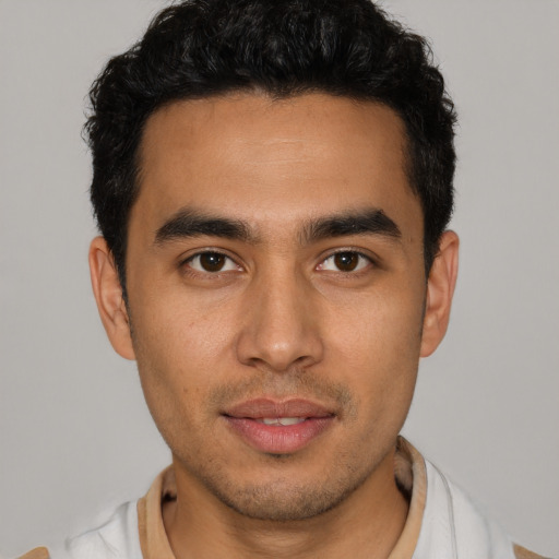 Joyful latino young-adult male with short  brown hair and brown eyes