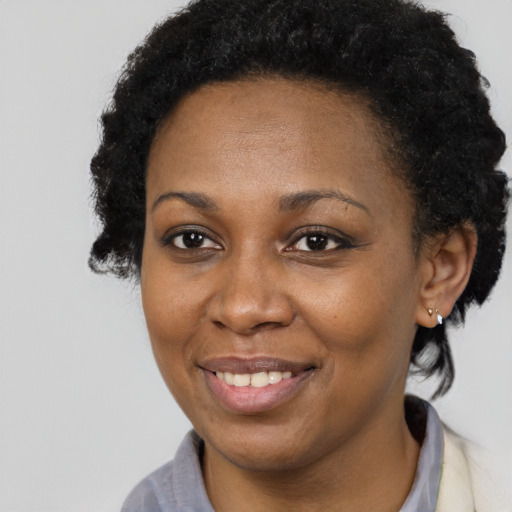 Joyful black adult female with medium  brown hair and brown eyes