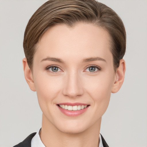 Joyful white young-adult female with short  brown hair and grey eyes