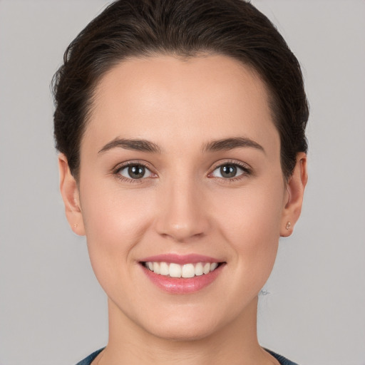 Joyful white young-adult female with short  brown hair and brown eyes