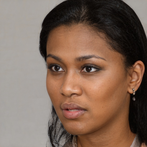 Neutral black young-adult female with medium  brown hair and brown eyes