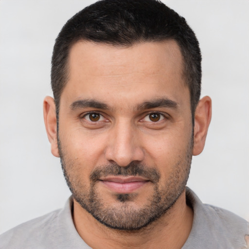 Joyful white young-adult male with short  black hair and brown eyes