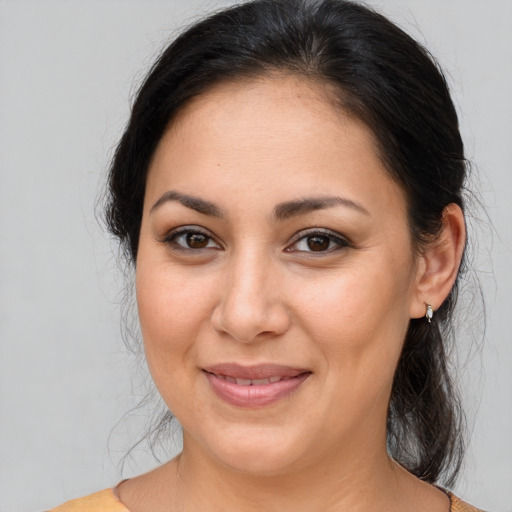Joyful latino adult female with medium  brown hair and brown eyes