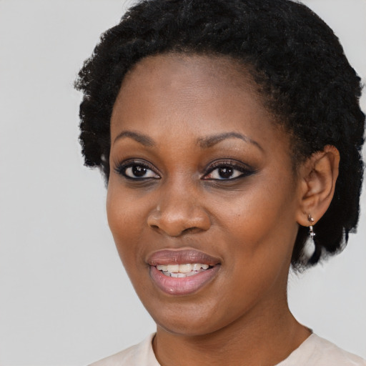 Joyful black young-adult female with short  black hair and brown eyes