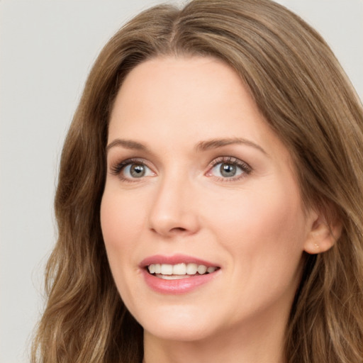 Joyful white young-adult female with long  brown hair and green eyes