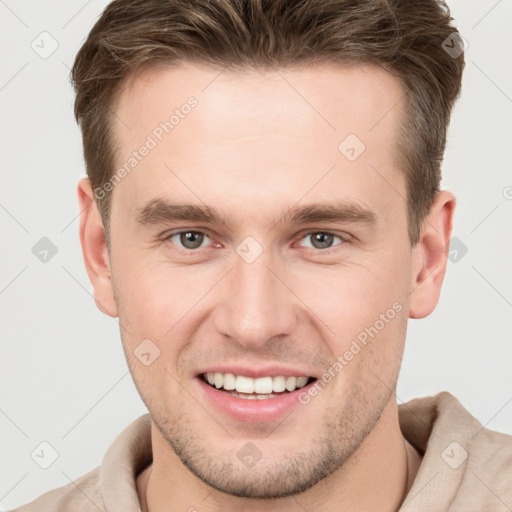 Joyful white young-adult male with short  brown hair and grey eyes