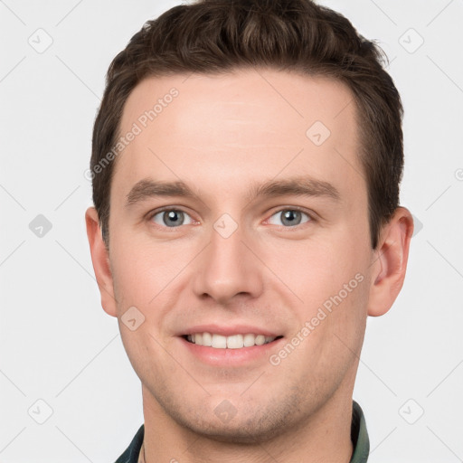 Joyful white young-adult male with short  brown hair and grey eyes