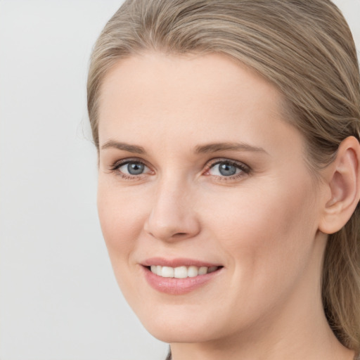 Joyful white young-adult female with medium  brown hair and blue eyes