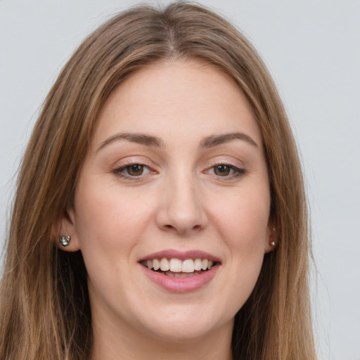 Joyful white young-adult female with long  brown hair and green eyes