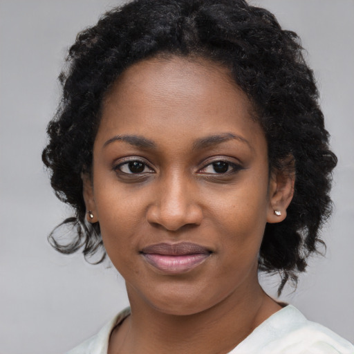 Joyful black young-adult female with long  black hair and brown eyes
