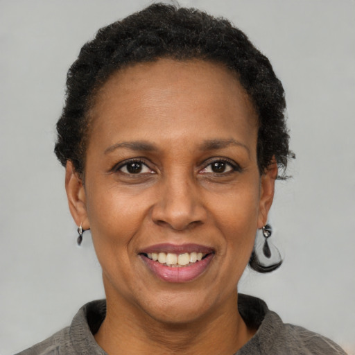 Joyful black adult female with short  brown hair and brown eyes