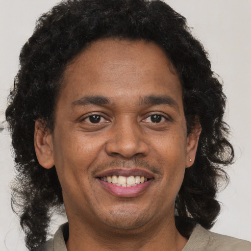Joyful black young-adult male with short  brown hair and brown eyes