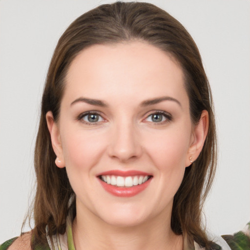 Joyful white young-adult female with medium  brown hair and grey eyes