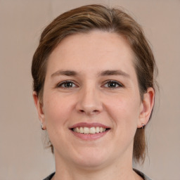 Joyful white young-adult female with medium  brown hair and grey eyes