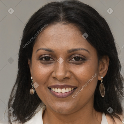 Joyful black young-adult female with long  brown hair and brown eyes