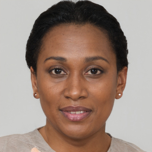 Joyful black adult female with short  black hair and brown eyes