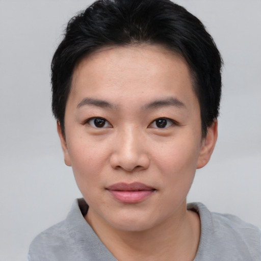 Joyful asian young-adult female with short  black hair and brown eyes