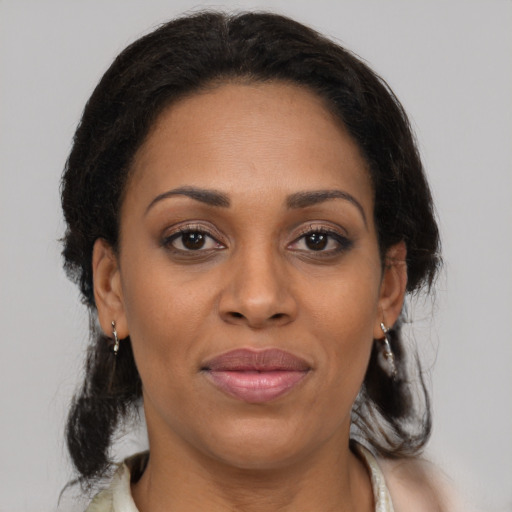 Joyful black adult female with medium  brown hair and brown eyes