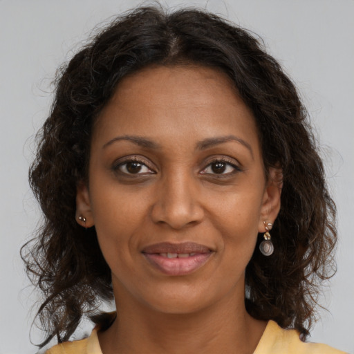 Joyful black adult female with medium  brown hair and brown eyes