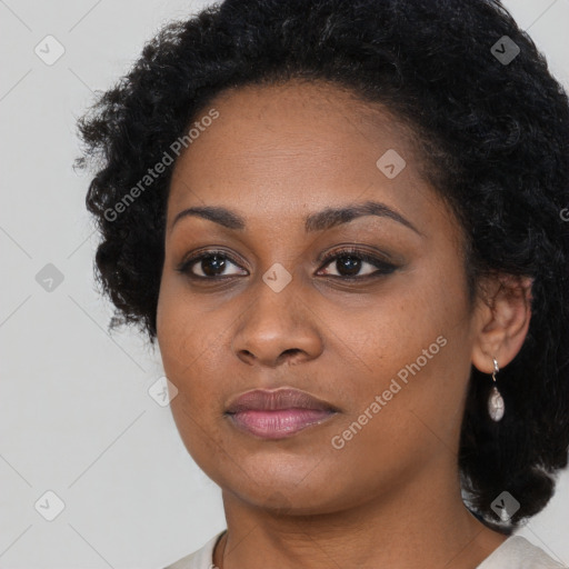 Joyful black young-adult female with long  black hair and brown eyes