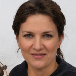 Joyful white adult female with medium  brown hair and brown eyes