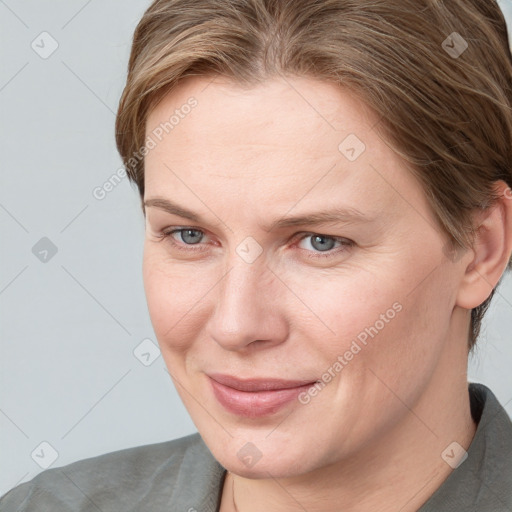 Joyful white adult female with medium  brown hair and blue eyes