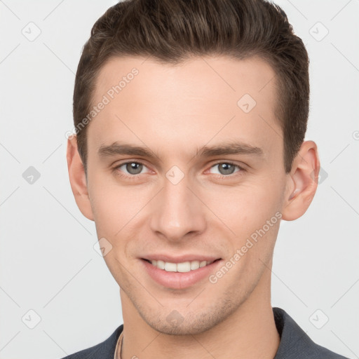 Joyful white young-adult male with short  brown hair and grey eyes