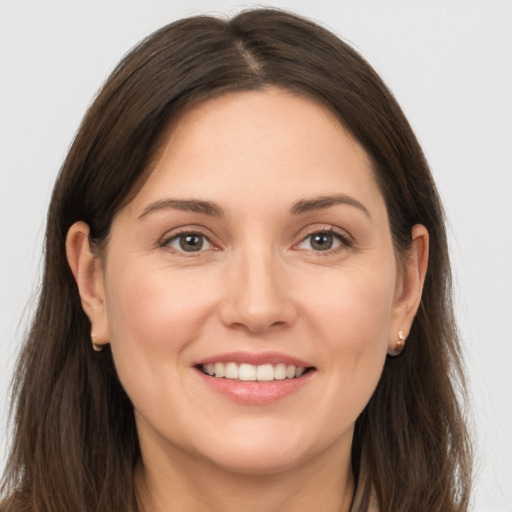 Joyful white young-adult female with long  brown hair and brown eyes