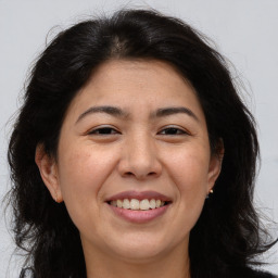 Joyful white adult female with long  brown hair and brown eyes