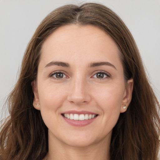 Joyful white young-adult female with long  brown hair and grey eyes