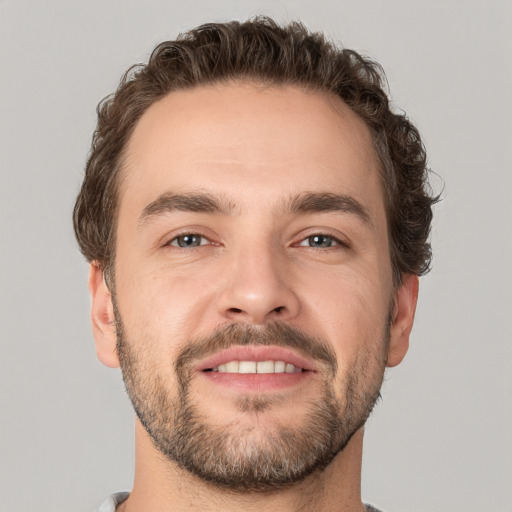 Joyful white young-adult male with short  brown hair and grey eyes