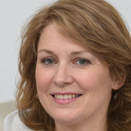 Joyful white adult female with medium  brown hair and grey eyes