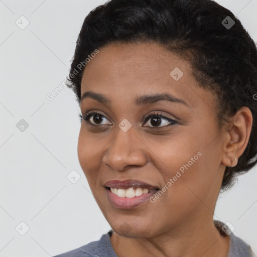 Joyful black young-adult female with short  black hair and brown eyes