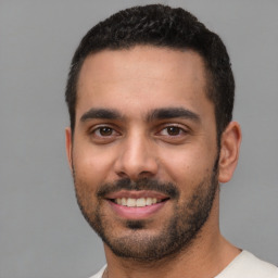 Joyful white young-adult male with short  black hair and brown eyes