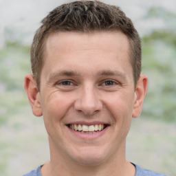 Joyful white young-adult male with short  brown hair and grey eyes