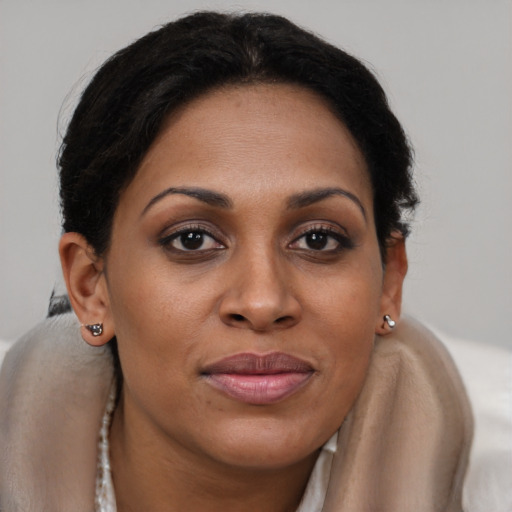 Joyful black young-adult female with long  brown hair and brown eyes