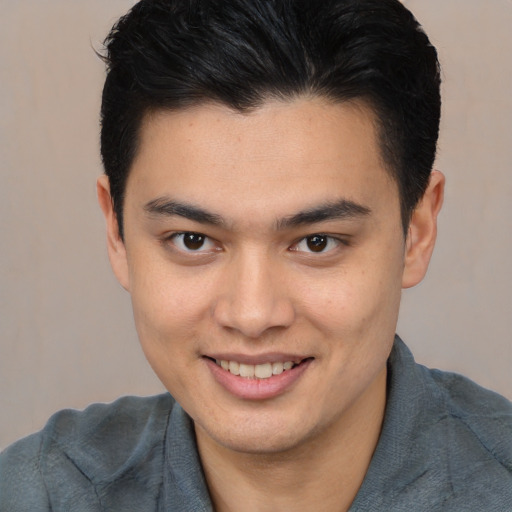 Joyful asian young-adult male with short  brown hair and brown eyes