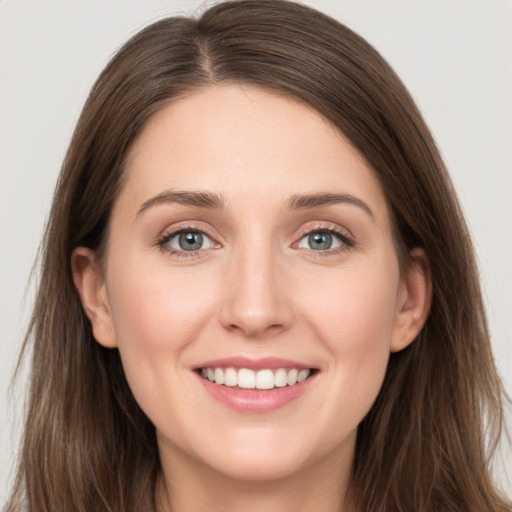 Joyful white young-adult female with long  brown hair and grey eyes