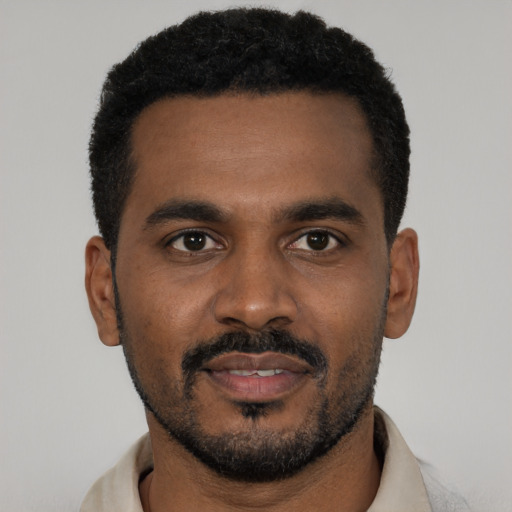 Joyful black young-adult male with short  black hair and brown eyes