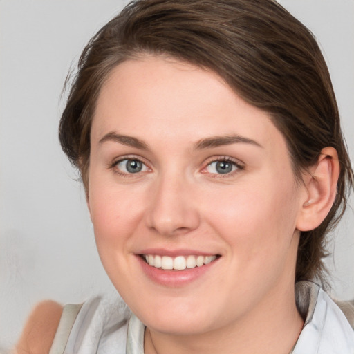 Joyful white young-adult female with medium  brown hair and blue eyes