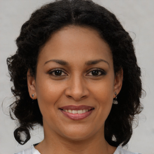 Joyful black young-adult female with medium  brown hair and brown eyes