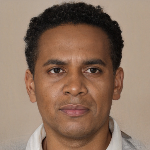 Joyful black adult male with short  brown hair and brown eyes