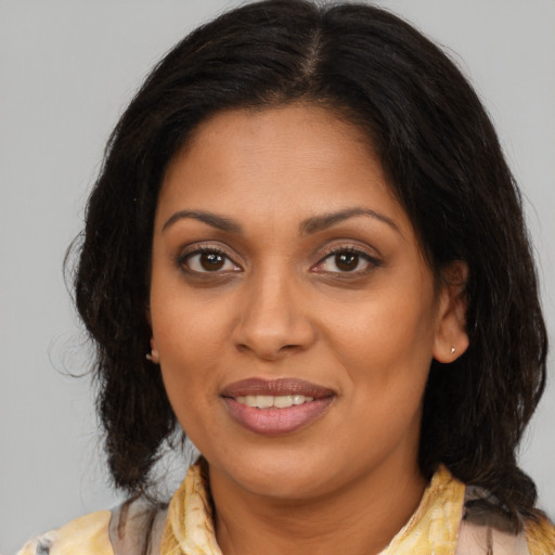 Joyful black young-adult female with medium  brown hair and brown eyes