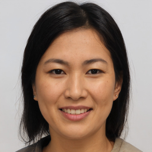 Joyful asian young-adult female with medium  brown hair and brown eyes