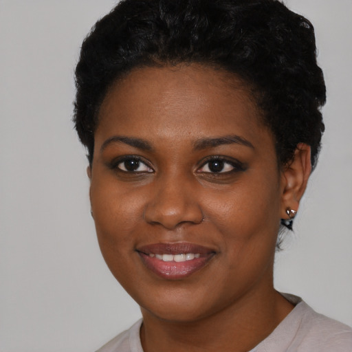 Joyful black young-adult female with short  brown hair and brown eyes