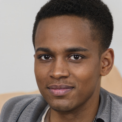 Joyful black young-adult male with short  brown hair and brown eyes