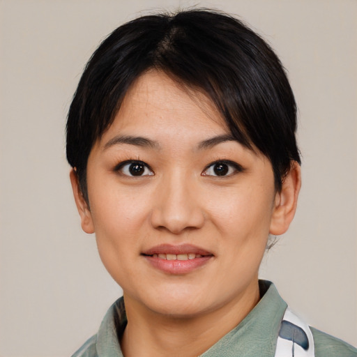 Joyful asian young-adult female with short  black hair and brown eyes