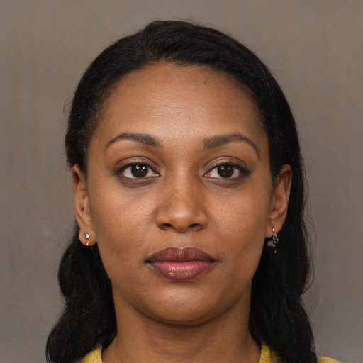 Joyful black young-adult female with long  black hair and brown eyes