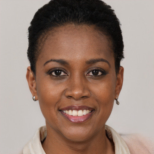 Joyful black young-adult female with short  black hair and brown eyes